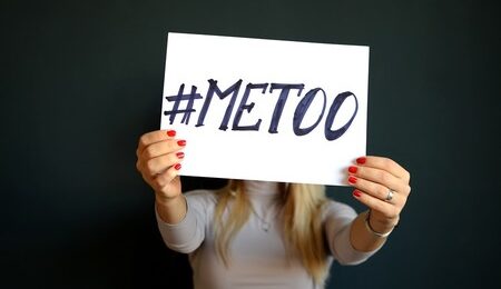 woman holding a piece of paper with #metoo