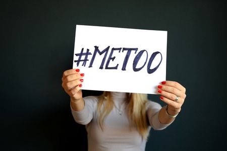 woman holding a piece of paper with #metoo