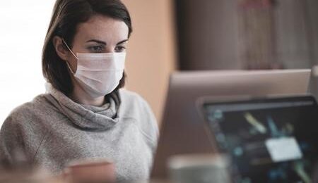 woman working at office with a mask